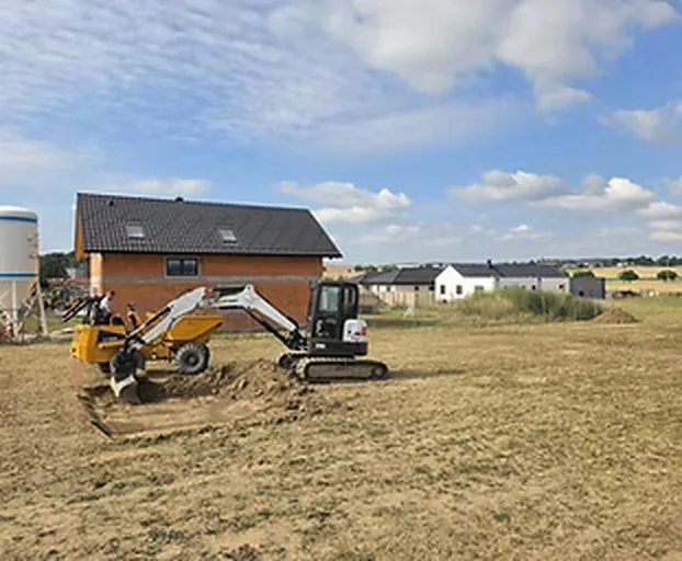 Příprava pozemku bagrem pro stavbu rodinného domu v Příbrami